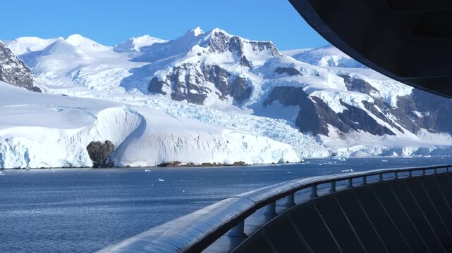 Cinematic Antarctica Cruise Ship Deck Adventure Travel Massive Glacier Mountain Covered in Snow. Stunning Clear Sunny Day in Wilhelmina Bay Blue Sky
