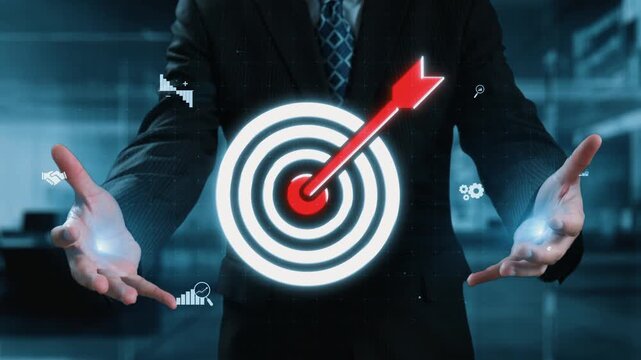 A businessman with outstretched hands is surrounded by digital graphics of a target and success elements, emphasizing goals in a contemporary corporate setting. Qubit