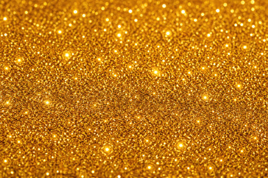 Shiny gold glitter texture background with bright sparkling particles