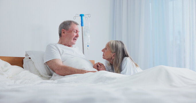 Sick, senior or couple in bed with drip for medical help, support or comfort in nursing home. Sad man, woman or empathy with patient or moment for understanding, love or compassion together in house