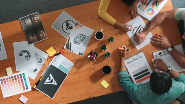 Top view of manager writing idea on sticky notes and explain idea about web design. Professional marketing team or programmer brainstorming idea while looking at tablet with color palette. Symposium.