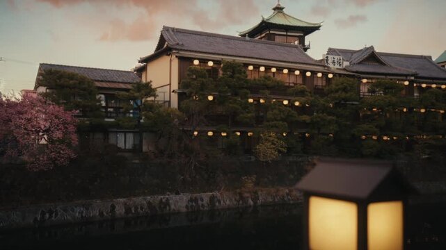 Wide dusk shot of the Tōkaikan historic ryokan reflected in the Matsukawa River, Ito, Shizuoka, Japan.
