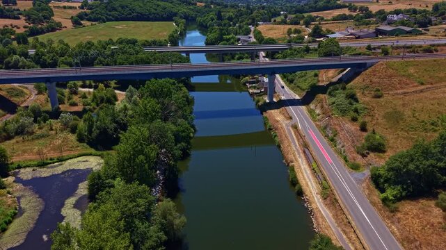 Armoricaine D31 crosses the Mayenne River in Change, Mayenne, Pays de la Loire, France, linking rural transport routes through a green river valley with farmland and woodlands, drone forward flyover.