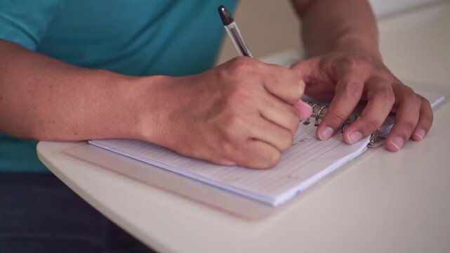 Person writes notes by hand, marks an error with a cross, then tears the paper from a notebook. Ideal for education, productivity, editing, and problem-solving concepts.