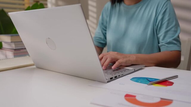 Close up shot of female hand using laptop for working, learning, searching, or surfing social media at home.