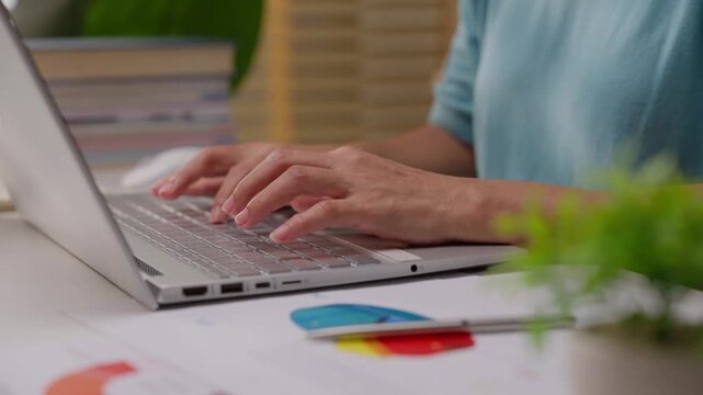 Close up shot of female hand using laptop for working, learning, searching, or surfing social media at home.