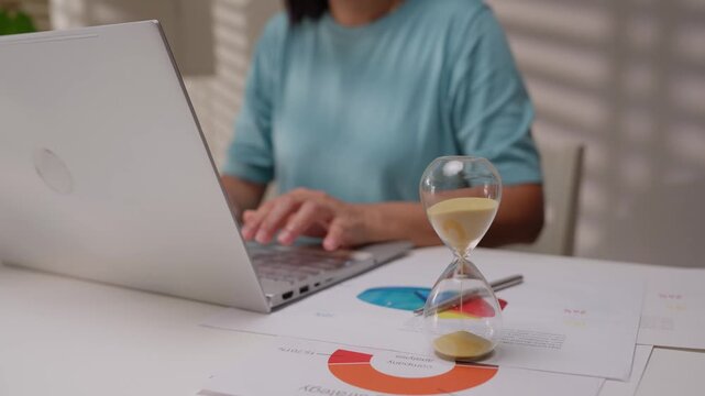 Young business woman working with hourglass.