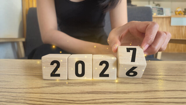 2026 to 2027 transition wooden blocks concept with glowing particles new year illustration