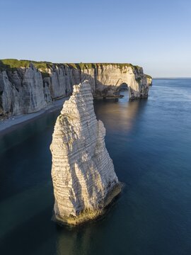 Aerial view of the distinctive Aiguille d'&Eacute;tretat rock pin in the morning sun, behind it the La Manneporte rock gate, &Eacute;tretat, Alabaster Coast, La C&ocirc;te d'Alb&acirc;tre, chalk cliffs, English Channel, Seine-Maritime, Normandy, France