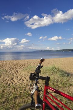 Red bike in front of a beach with a view of the sea and a clear sky, bicycle tours, cycle tourism, Lake V&auml;ttern, J&ouml;nk&ouml;ping, Sweden