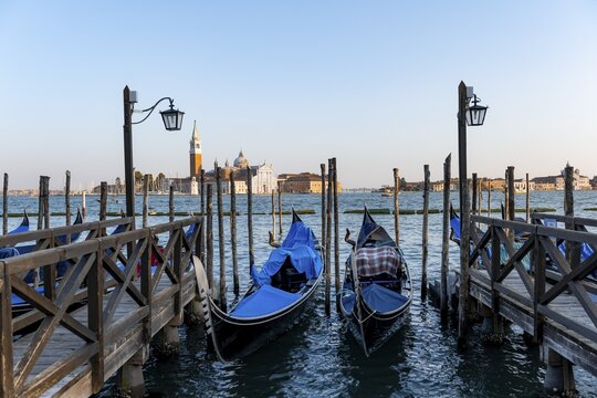 Venetian gondolas, boat launch at St. Mark's Square, San Giorgio Maggiore church in the evening light, Venice, Veneto, Italy