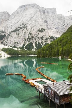 Summer vibrant landscape viewpoint s Lago di Braies Lake in italian Dolomites mountains in northern Italy. Drone aerial photo with Wooden boats and beautiful reflection in calm water at sunset