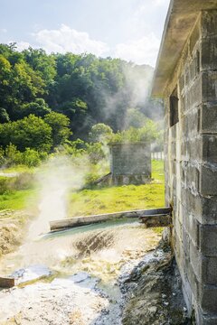 Close up of steaming hot springs in sunny summer day in picturesque georgian landscape in background. Georgia