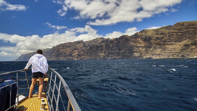 Los Gigantes, A man at the helm of a boat enjoying the view of the rocky coast, whale watching boat tour, whale watching, dolphins, west coast, Tenerife, Canary Islands, Spain