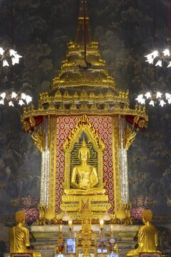 Golden meditating Buddha surrounded by wall paintings with Buddhist teachings and representations of Buddha's disciples, Wat Makut Kasatriyaram Ratchaworavihan, Phra Nakhon District, Old Bangkok, Thailand