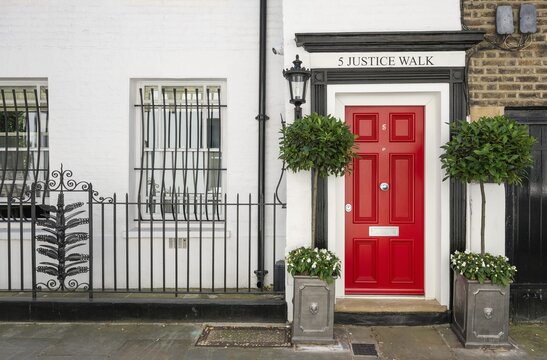 Classic red door with black frame and plants on both sides, white house facade, 5 Justice Walk, Chelsea, London, Great Britain, England, Great Britain