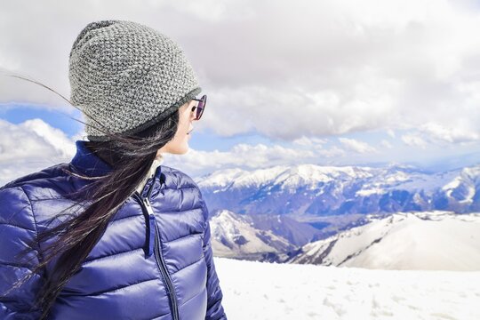 Caucasian female person enjoy winter mountains panorama in sunny ski resort. Right empty blank space copypaste winter solo holiday background.Gudauri.Georgia