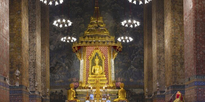 Golden meditating Buddha surrounded by wall paintings with Buddhist teachings and representations of Buddha's disciples, Wat Makut Kasatriyaram Ratchaworavihan, Phra Nakhon District, Old Bangkok, Thailand