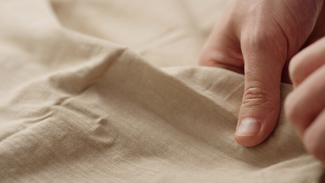 man hand checking natural cotton jersey cloth