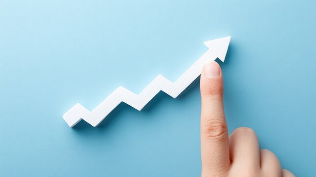 A hand pointing at an upward trending graph arrow on blue background. Business growth and success concept.