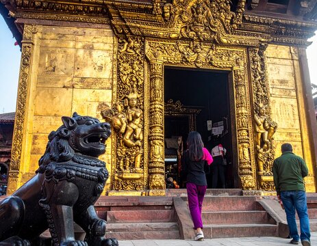 A close-up of an extraordinarily ornate golden temple wall exterior