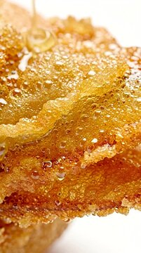 Sweet syrup pouring over textured crispy phyllo layers for traditional dessert presentation
