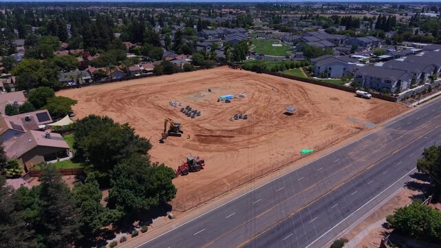 Still Aerial Drone Shot Over Construction Site With Worker Heavy Machinery Dirt Piles Neighborhood and Apartment Complex in Fresno California