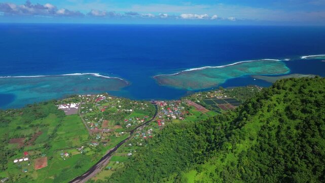 Aerial drone view village of surf town Teahupo'o wave lagoon End of the Road Tahiti French Polynesia sunny morning blue sky neighborhood lagoon surfing Passe Havea coral reef Vaiau River ridge upwards