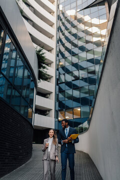 Diverse business people walking and talking in urban setting