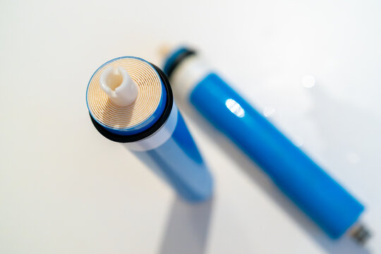 Precision blue filter cartridge for reverse osmosis with distinct spiral design and white outlet tip for optimal fluid filtration. 