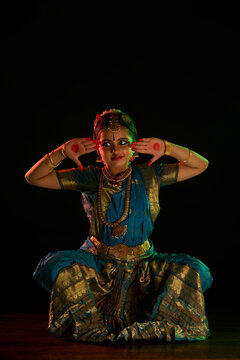 Young bharatnatyam dancer doing a ardha chandra mudra during a performance. 