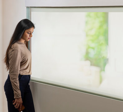 Woman standing in front of the window at home