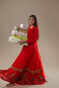 Beautiful woman in ethnic suit holding gift boxes in her hand