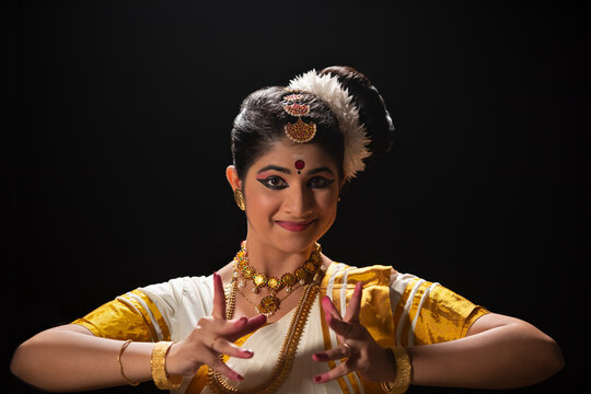 Mohiniattam dancer smiling while making Ardhachandra mudra