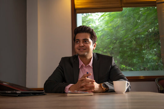 AN OFFICE EXECUTIVE SMILING AND LOOKING ABOVE 