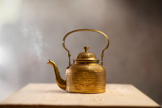 Brass kettle blowing hot air kept on a table