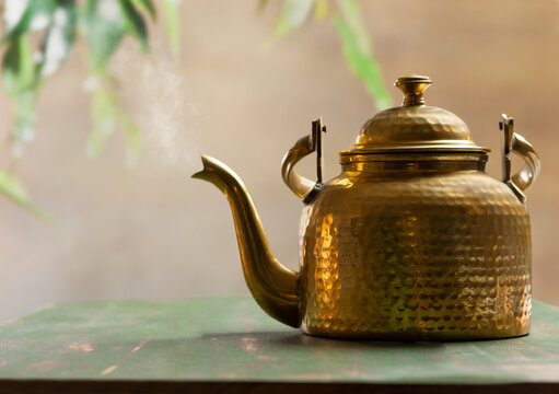 Kettle blowing steam kept on a table outdoor