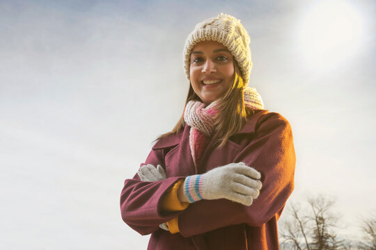 PORTRAIT OF A YOUNG WOMAN IN WINTER'S CLOTHES HAPPILY LOOKING AT CAMERA