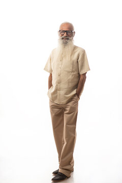 AN OLD MAN WITH LONG BEARD CONFIDENTLY STANDING IN FRONT OF CAMERA