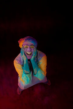 Man with a bright smile on his face celebrating Holi 
