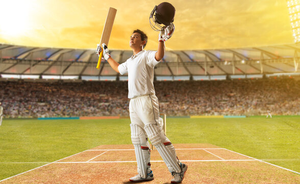 Cricketer celebrating at the pitch with his arms raised 