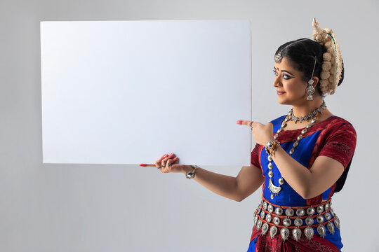 Odissi dancer pointing at blank placard