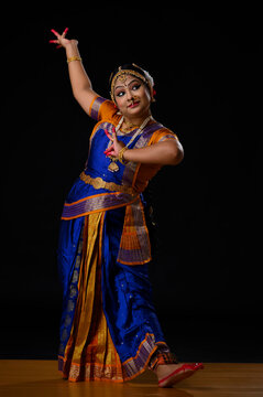 Kuchipudi dancer doing Alapadamam and Katakamukha mudra while performing on stage