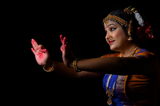 Kuchipudi dancer showing a petal through Aralam mudra