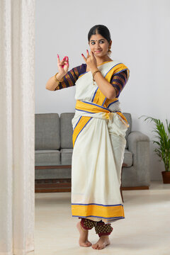 Woman in saree practicing Katakam mudra depicting Lord Krishna playing flute