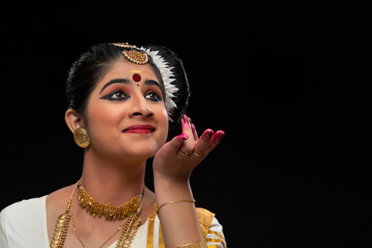 Mohiniattam dancer collecting droplets of rainwater in her hand 