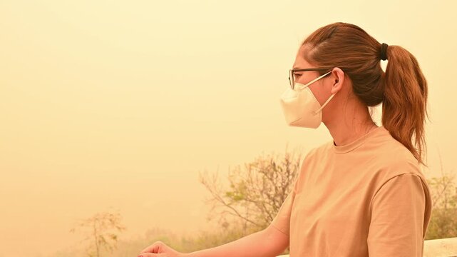 Asian woman looking to the view covered by bad air pollution (PM2.5). A harmful thing is toxic air pollution.