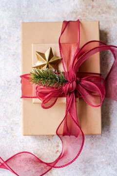 Close-up overhead view of two Gift boxes Decorated with a fir sprig, star ornament and red ribbon tied in a bow