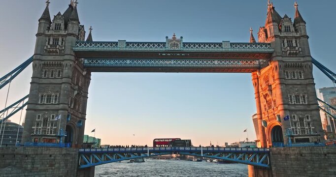 Tower Bridge iconic London landmark. Rising majestically over the River Thames bathed in the warm golden glow of a beautiful sunset. Symbolizing travel and history of United Kingdom. Rise up panorama