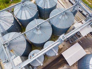 Large grain storage facility located in a rural area with multiple silos and transportation structures visible from above © DSMT